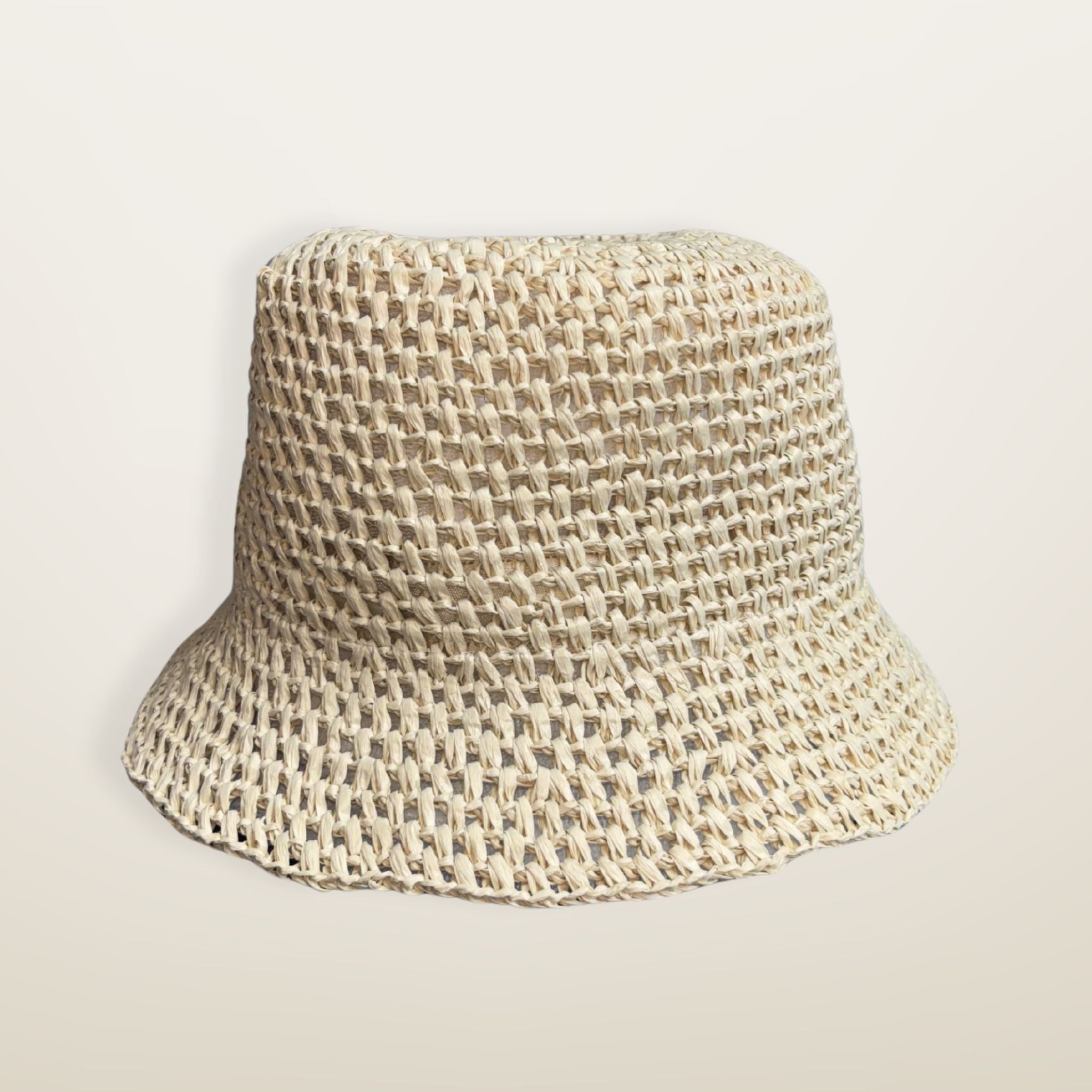 NATURAL woven RAFFIA bucket hat with a JE brand label on a light beige background