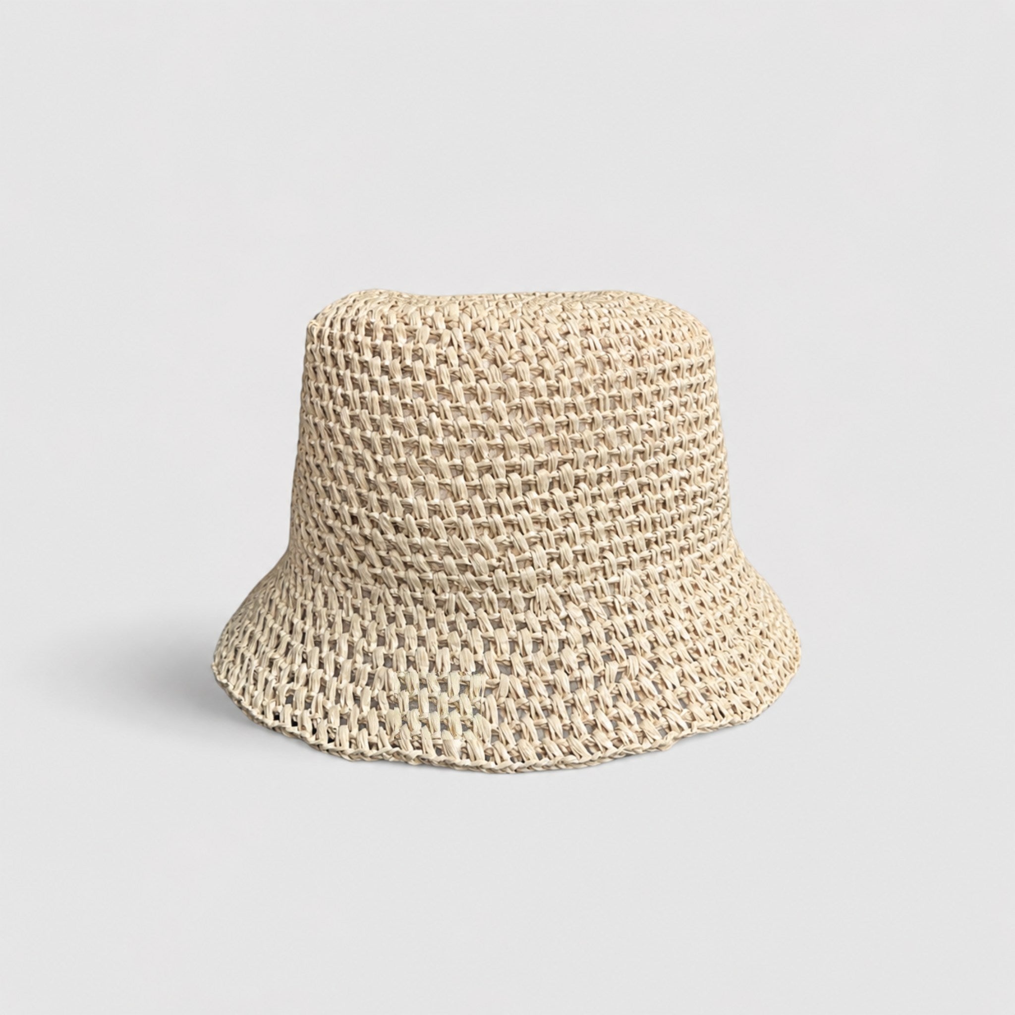 Natural Brown woven bucket hat with an orange label on a light gray background