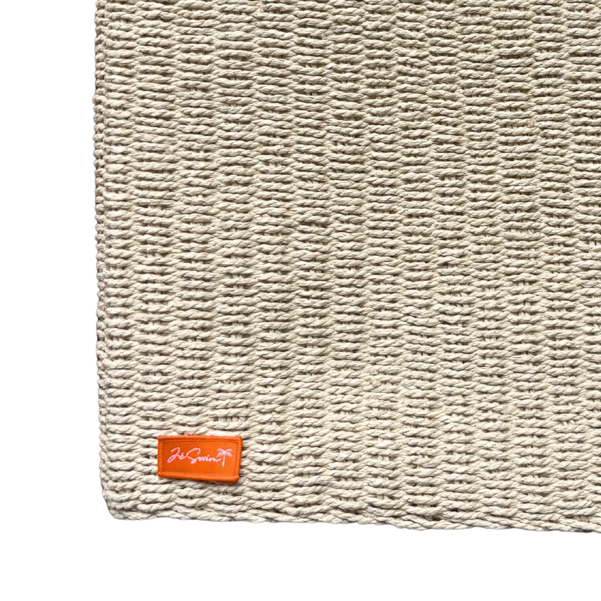 Natural raffia bag corner with a brand logo on a white background