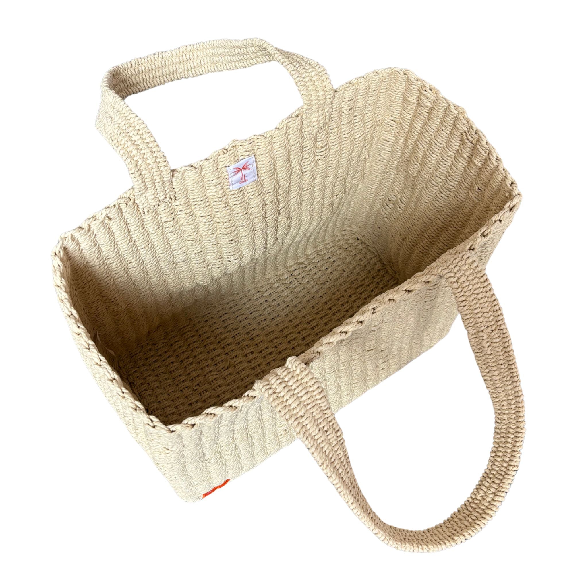 Natural raffia bag with a handle on a white background