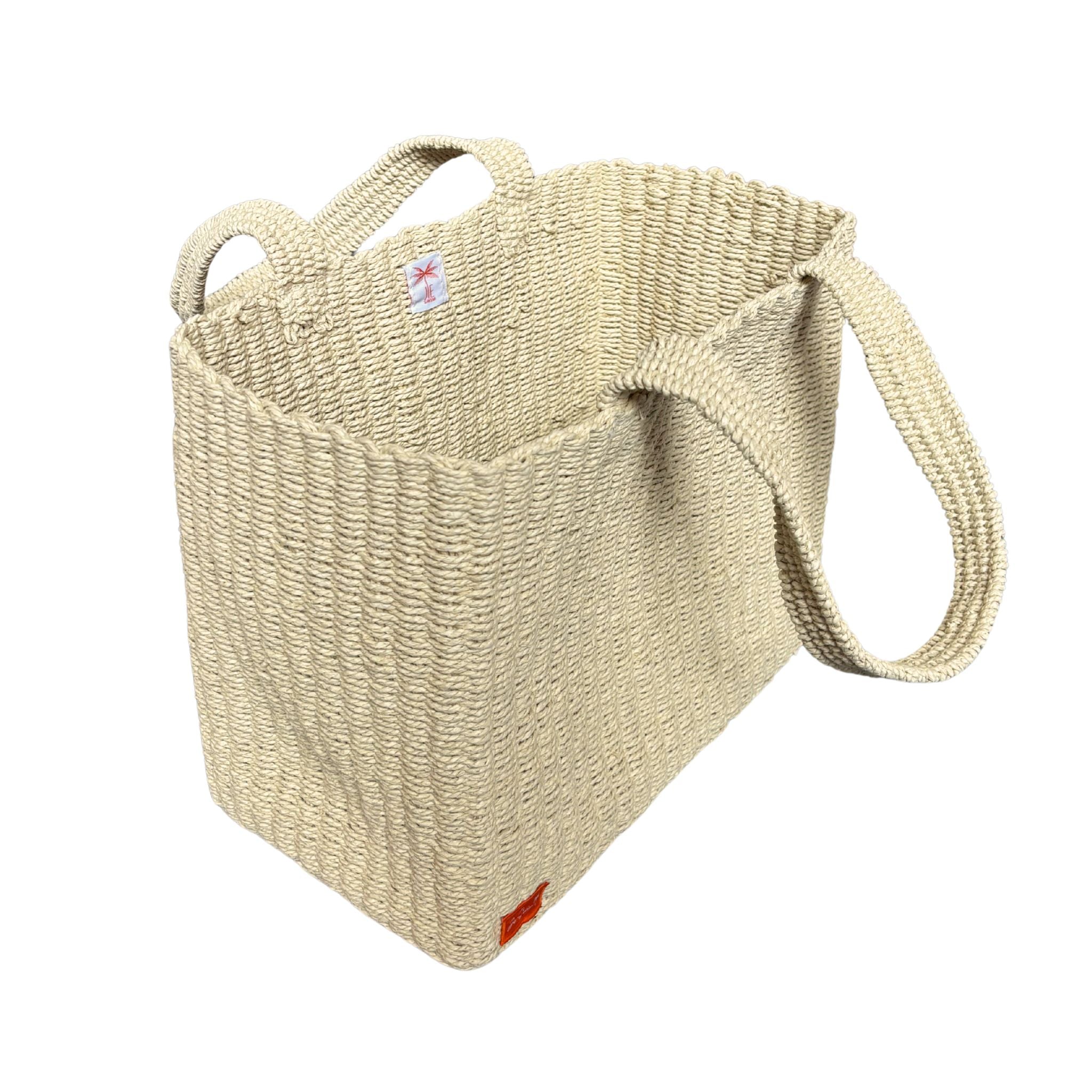 Natural raffia woven bag with a strap on a white background