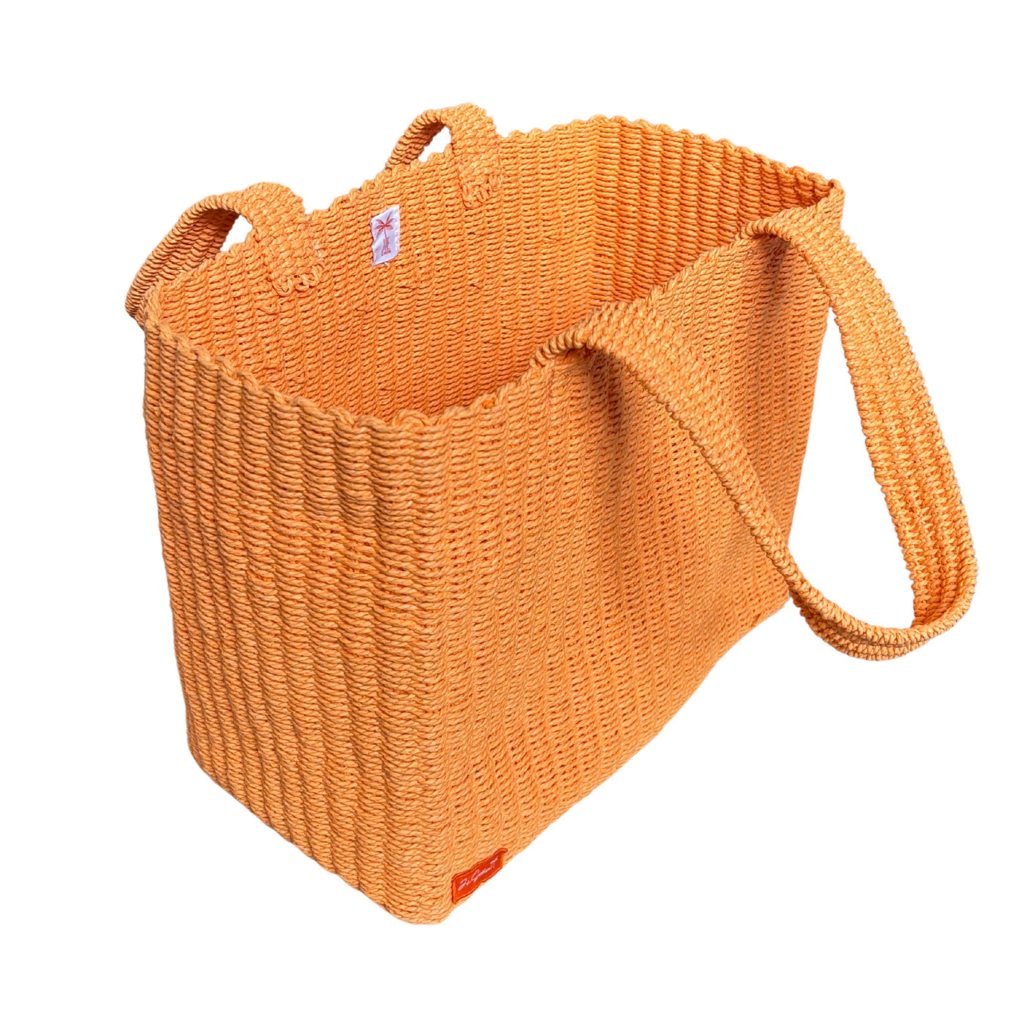 Orange raffia bag with a handle on a white background