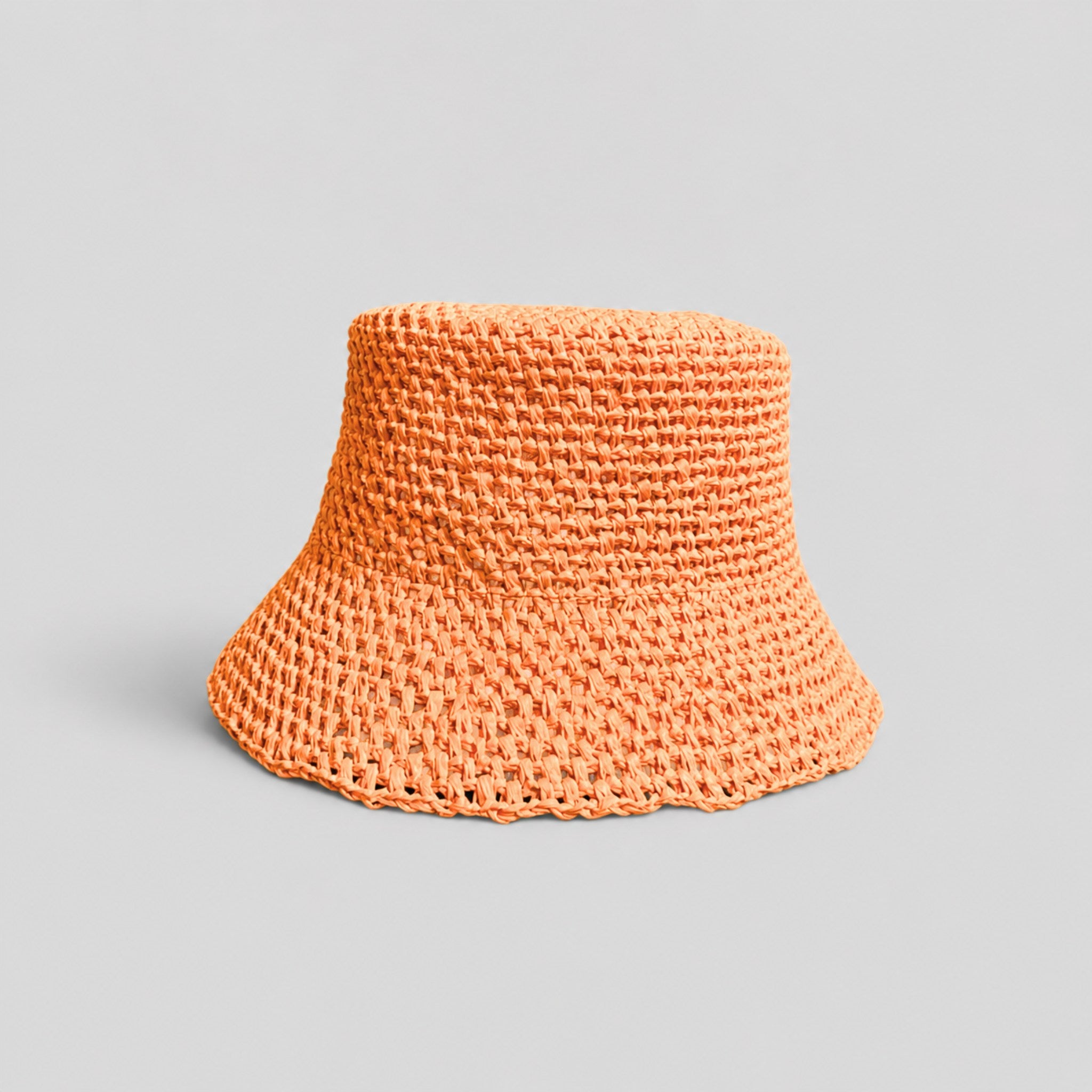 Orange woven raffia bucket hat with a brand logo on a gray background