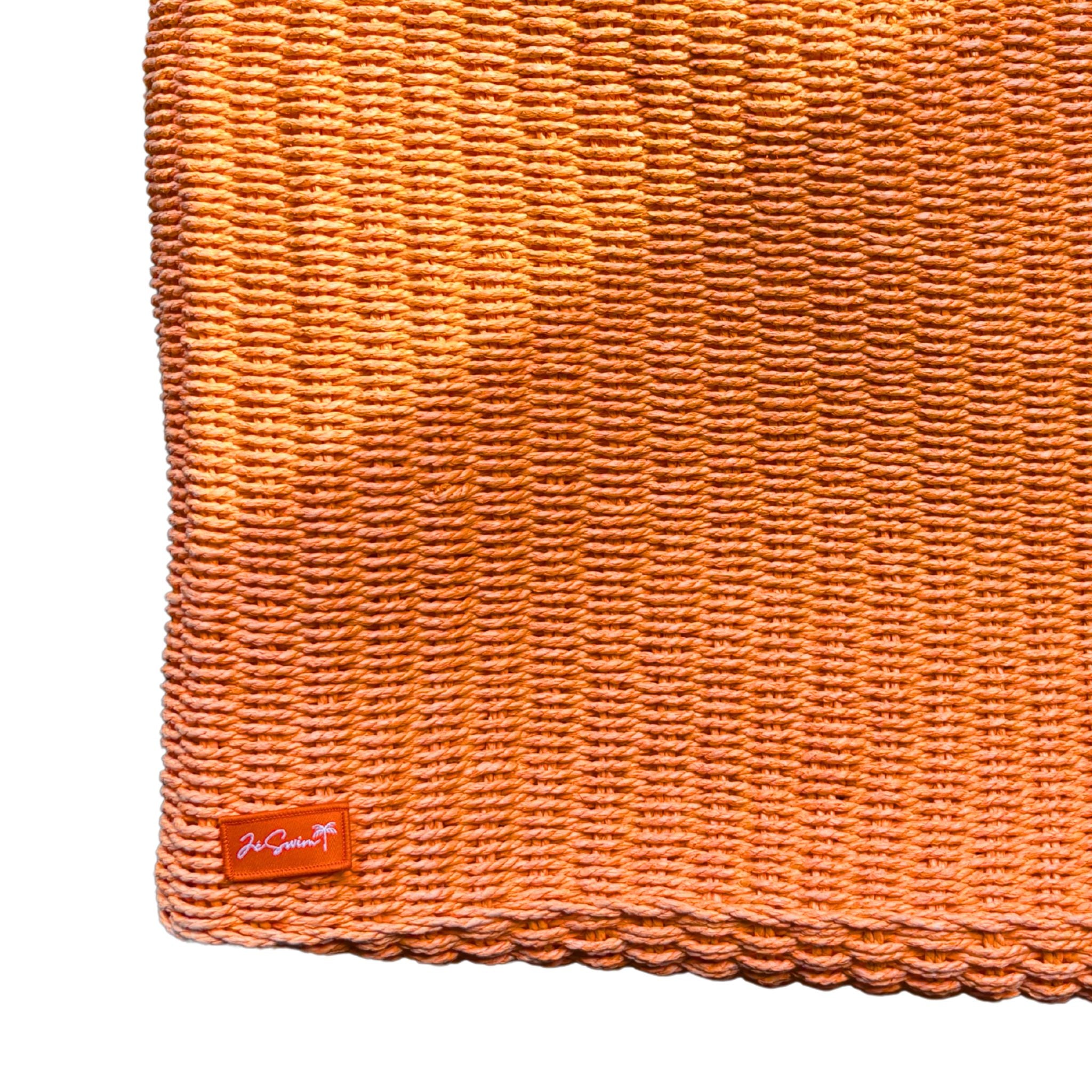 Orange raffia bag corner with a brand logo on a white background