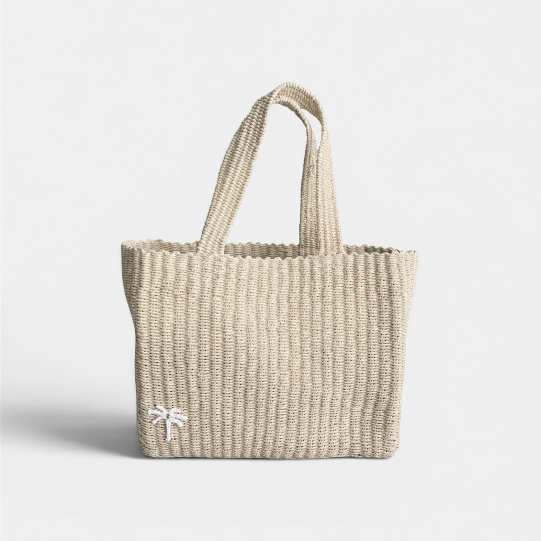 Natural beige woven tote bag on a light gray background with white palm tree details