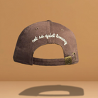 Brown JE Swim baseball hat with "not so quiet luxury" embroidered in white.