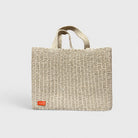 Natural woven tote bag, front view with logo patch.