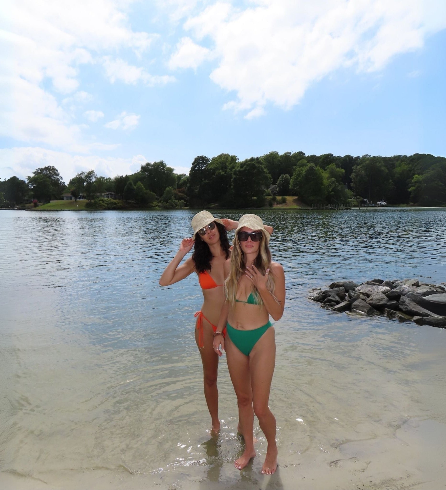Two women in swimsuits standing on a beach with trees and water in the background 20% OFF EVERYTHING ALL WEEKEND 8/29/25-9/1/25