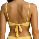 Yellow bikini top with a tie back and adjustable straps on a white background