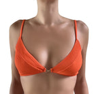 Orange bikini top with palm tree charm on a white background