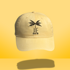 Yellow JE Swim baseball cap with a black palm tree logo.